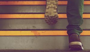 Image: person walking up steps. Topic: Steps to Divest & Reinvest: From Fossil Fuels to Clean Energy