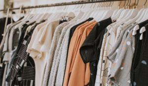 Image: clothes hanging on hangers in shop. Topic: 5 ways to shop for sustainable clothes online