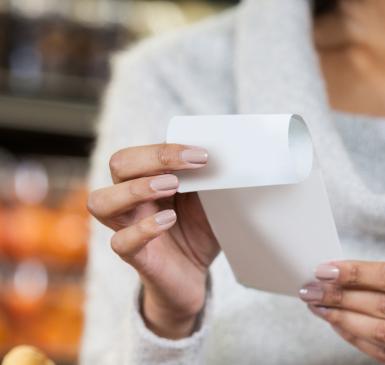 Image: woman holding paper receipt Topic: Skip the Slip to reduce store receipts