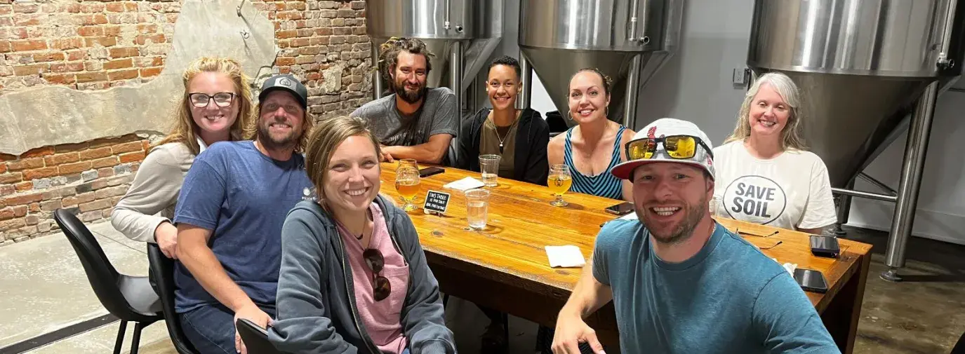Brian James and Green America team members sitting around a table at a brewery.