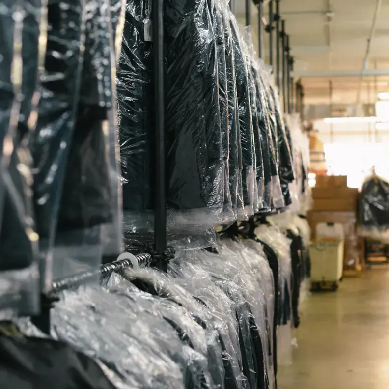 Image: suit rack at dry cleaners. Topic: Green Dry Cleaning